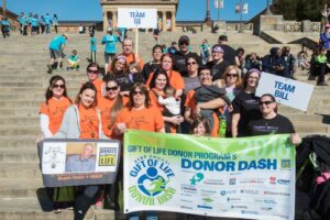 People hold up signs and banners on building steps.