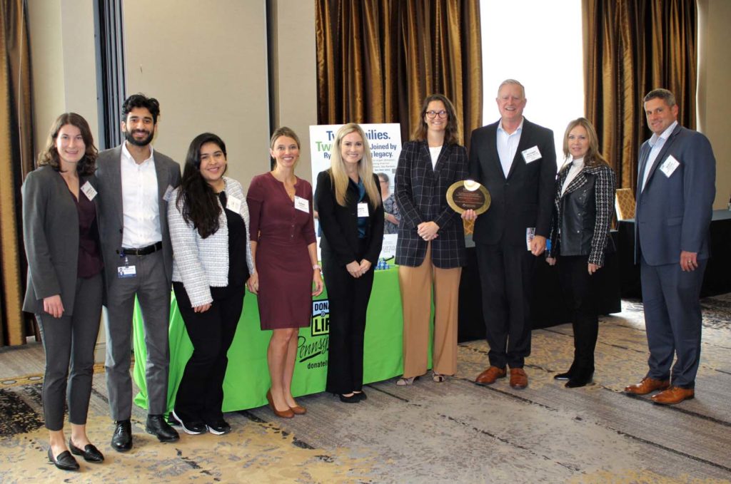 A group of people pose for a picture with an award