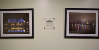 Two photos hang on the wall between a plaque commemorating the photographer.