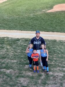 A man poses for a picture with his three children