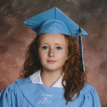 A high school student in their cap and gown