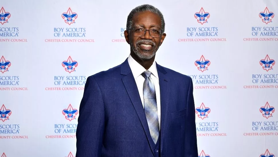 A man in formal attire poses for a photo.