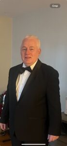 A man in a tuxedo poses for a photo