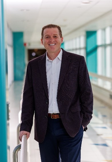 A man poses for a picture in a hospital. 
