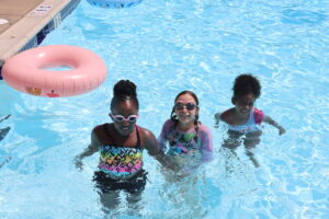 Children in swimming pool pose for a picture.