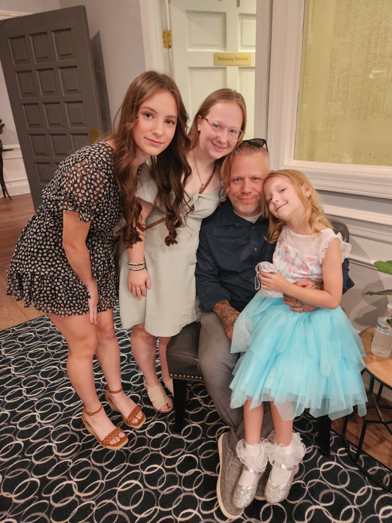 Tommy Ellis smiles for a picture with his three daughters - Angelina, Mia and Lily.