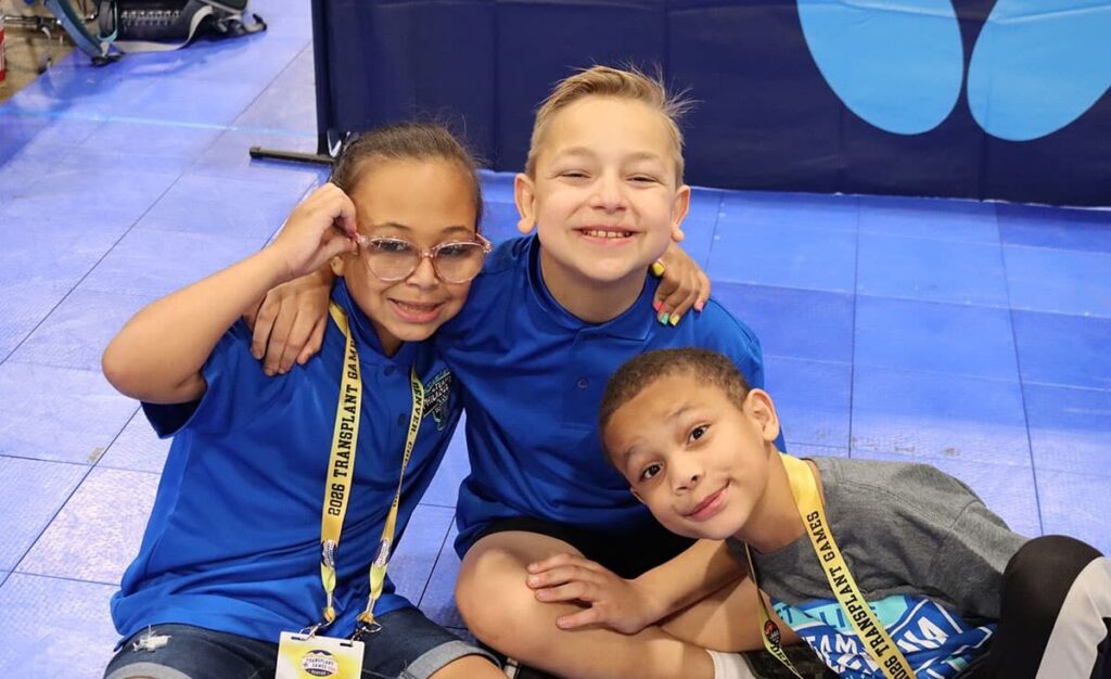Three pediatric transplant recipients smile and laugh.