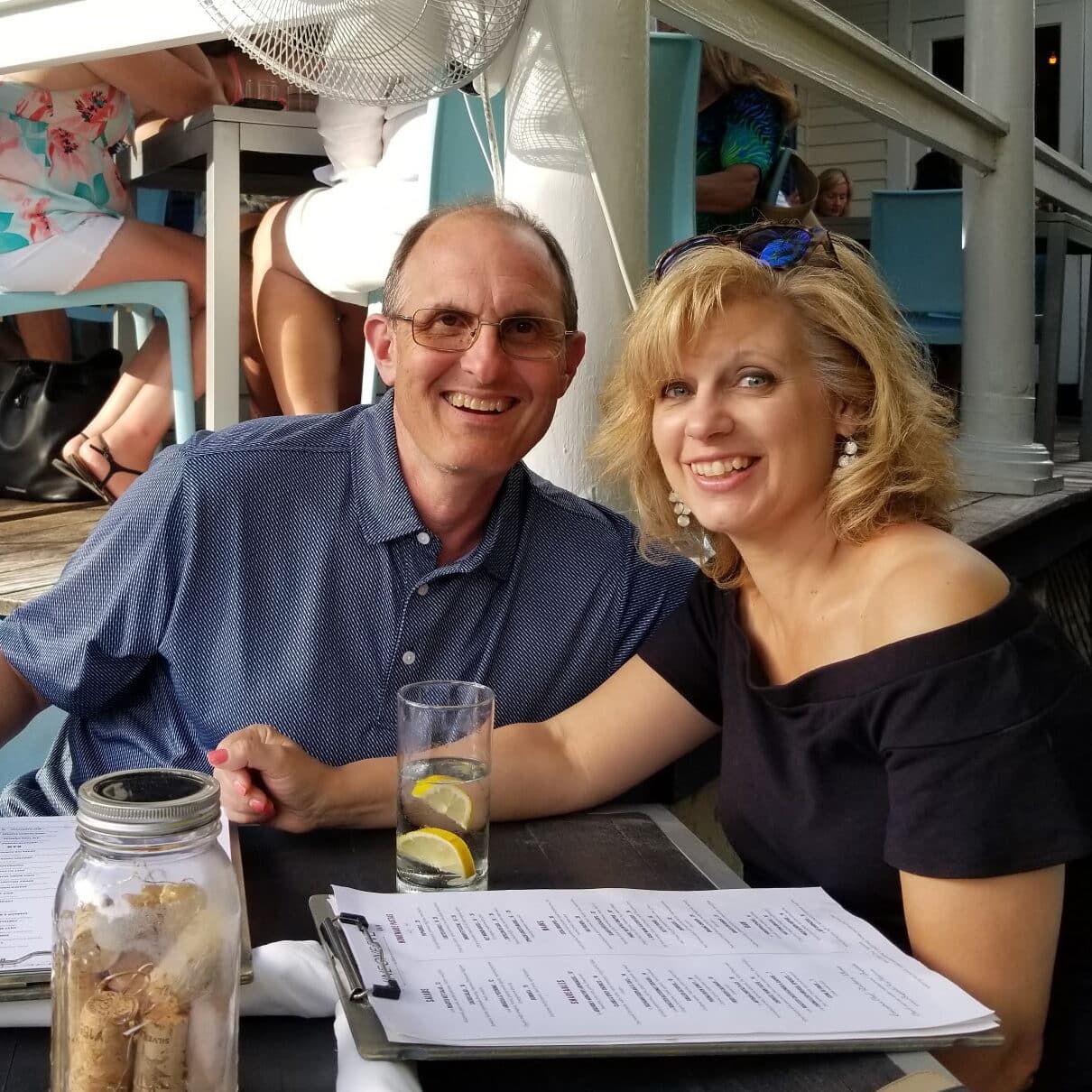 Tom smiles for a picture while dining out with his wife.