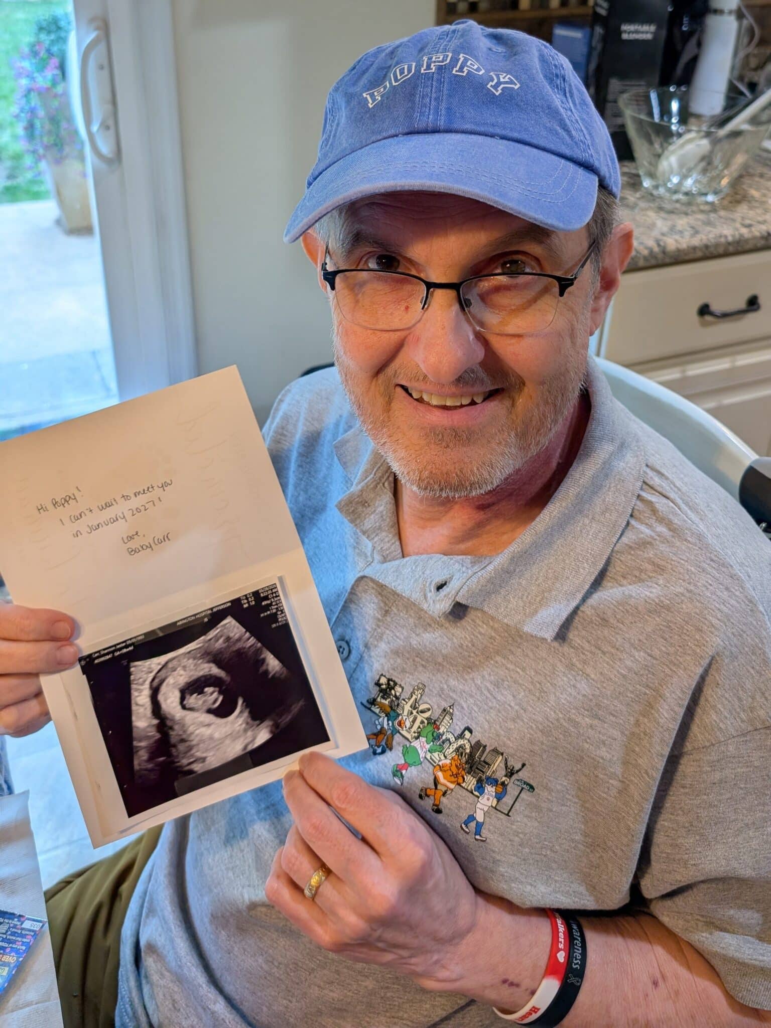 Tom shows an ultrasound of his grandchild.